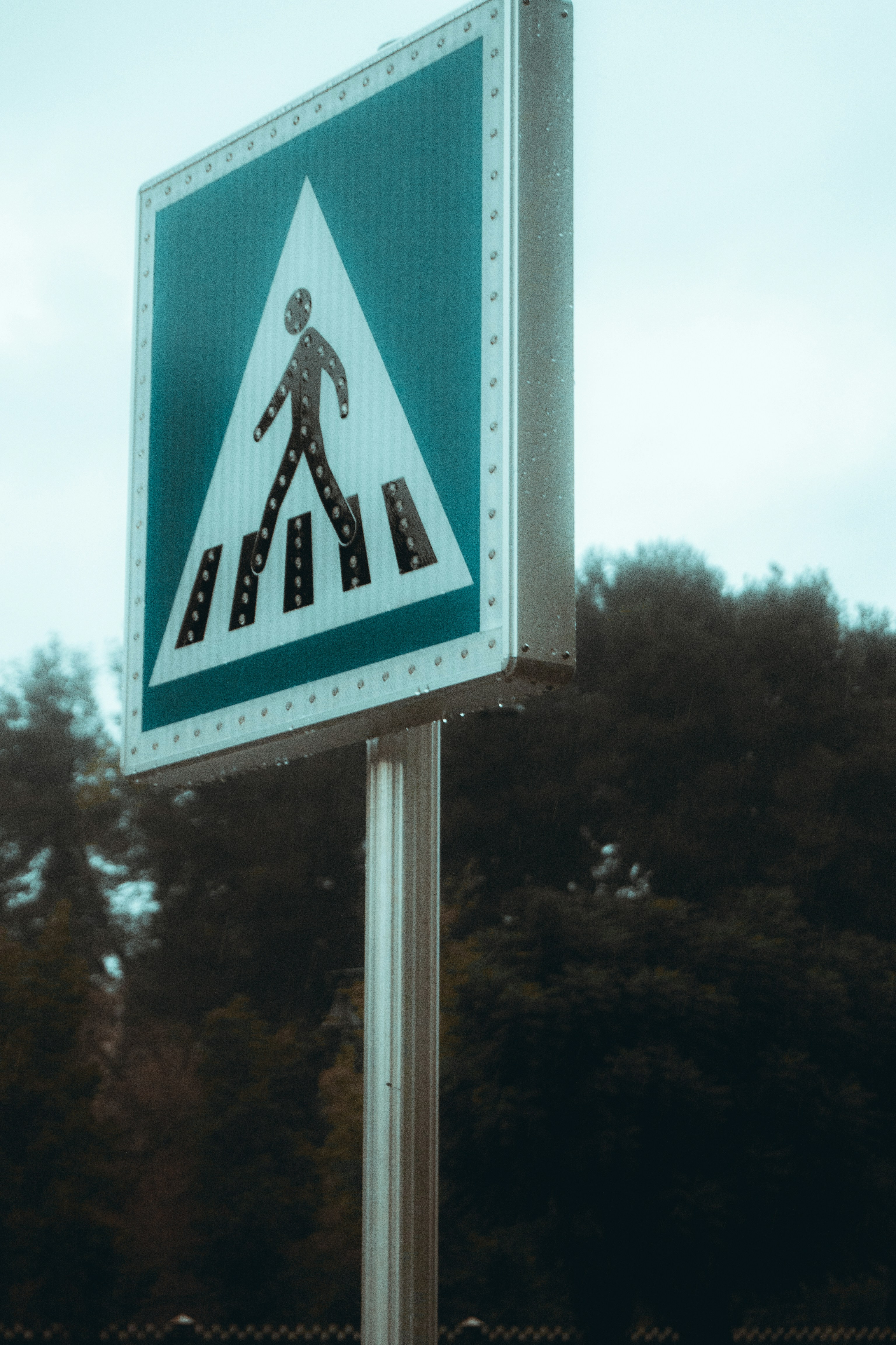 a street sign with a pedestrian crossing on it